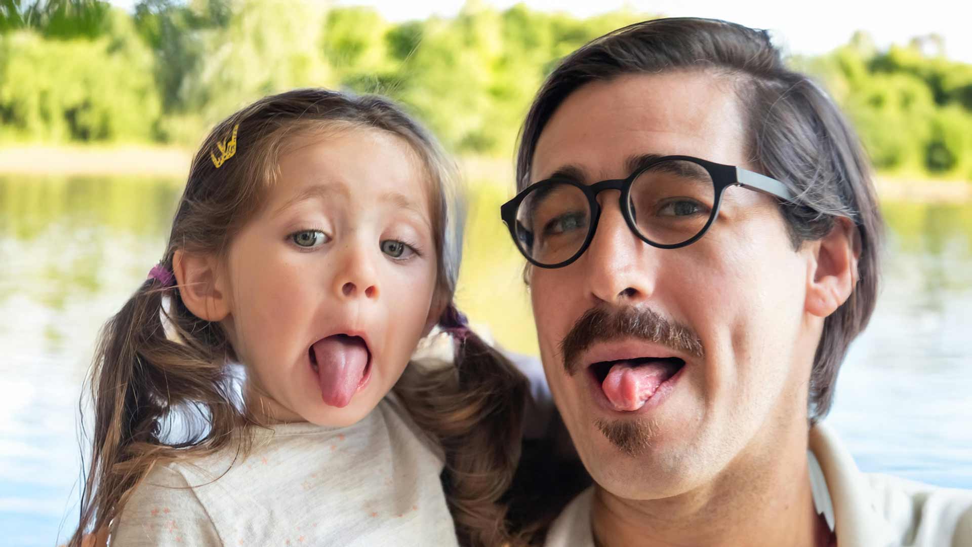 Tochter und Vater strecken Zunge raus